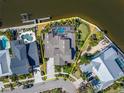Aerial view of waterfront home with screened pool, boat dock, and manicured backyard at 5616 Seagrass Pl, Apollo Beach, FL 33572