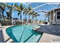 Sparkling pool in screened enclosure with waterfall feature and patio with palm tree views at 5616 Seagrass Pl, Apollo Beach, FL 33572