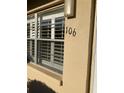 A close-up view of window with white shutters featuring the unit number '106' on the exterior wall at 5750 80Th N St # A106, St Petersburg, FL 33709