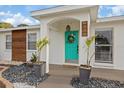 Inviting entryway with a teal door, stone ground cover and tasteful landscaping, adding a pop of color at 6339 S Lansdale Cir, Tampa, FL 33616
