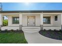 Inviting front porch with decorative columns and large windows at 7235 Peacock Ln, Englewood, FL 34224