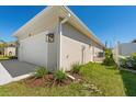 Side view of home with an attached two-car garage and manicured landscaping at 109 Beau Rivage Dr, Rotonda West, FL 33947