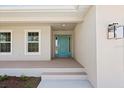Covered front porch featuring a vibrant blue front door with sidelights and transom window at 109 Beau Rivage Dr, Rotonda West, FL 33947