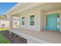 Inviting front porch with modern lighting, leading to a bright turquoise front door at 109 Beau Rivage Dr, Rotonda West, FL 33947