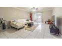 Cozy living room features tile flooring, a comfortable white sofa, and sliding door access at 12960 Trade Port Pl, Riverview, FL 33579