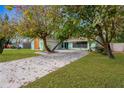Inviting home with a long driveway and a well-manicured lawn, surrounded by mature trees at 1710 Orange Hill Way, Brandon, FL 33510