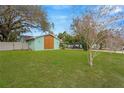 Spacious and well-kept side yard with lush green grass, enclosed by a white fence for privacy at 1710 Orange Hill Way, Brandon, FL 33510