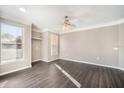 Bright bedroom featuring wood floors, a ceiling fan, and ample natural light from two windows at 17978 Villa Creek Dr, Tampa, FL 33647