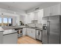 Modern kitchen with stainless steel appliances, light wood floors, white cabinets, and stone countertops at 226 5Th N Ave # 901, St Petersburg, FL 33701
