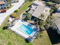 Aerial shot of a community pool with plenty of lounge chairs and palm trees at 25 Windrush Bay Dr # 25, Tarpon Springs, FL 34689