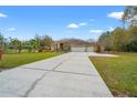 Home with a long driveway that leads to a three car garage at 27930 Ravens Brook Rd, Wesley Chapel, FL 33544