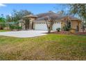 Home showing three car garage and side yard at 27930 Ravens Brook Rd, Wesley Chapel, FL 33544