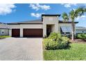 Charming single-story home featuring a three-car garage, manicured lawn, and decorative palm tree at 31999 Surfton Knot Ct, San Antonio, FL 33576