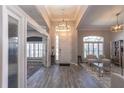 Welcoming foyer with stylish wood-look flooring, elegant lighting fixture, and views into other rooms at 3233 Russett Pl, Land O Lakes, FL 34638