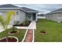 This home boasts a charming entrance with decorative landscaping at 35478 Bellington Blvd, Zephyrhills, FL 33541