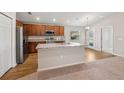 A kitchen featuring stainless steel appliances, an island with sink, and modern wood flooring at 35478 Bellington Blvd, Zephyrhills, FL 33541