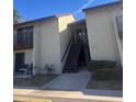Exterior front view of condo unit with stairs leading to a second-story entrance at 4215 E Bay Dr # 1701B, Clearwater, FL 33764