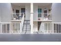 Condo entrance with stairs leading to units on the second floor with white railings and doors at 5279 Isla Key S Blvd # 313, St Petersburg, FL 33715