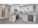 Well-lit kitchen featuring white cabinets, stainless steel appliances, and modern countertops at 536 63Rd S Ave, St Petersburg, FL 33705