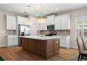 Modern kitchen with stainless steel appliances, white cabinets, and an island with a white countertop at 5807 Silver Sun Dr, Apollo Beach, FL 33572