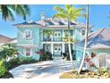 Beautiful light blue home with a second story porch, white trim and a well landscaped yard at 615 Islebay Dr, Apollo Beach, FL 33572