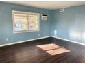 Bedroom featuring hard wood floors, bright blue walls, and a window unit at 624 Folsom S St, St Petersburg, FL 33707