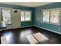 Bright living room featuring wood floors, blue walls and multiple windows allowing lots of natural light at 624 Folsom S St, St Petersburg, FL 33707
