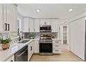 Modern kitchen featuring stainless steel appliances, quartz countertops, white cabinets and pantry, and bright lighting at 6921 Alken Cir, New Port Richey, FL 34653