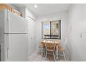 A compact dining area with a small table and chairs, adjacent to a large white refrigerator at 725 83Rd N Ave # 205, St Petersburg, FL 33702