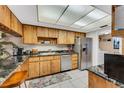 Kitchen featuring stainless steel appliances, wood cabinets, and granite countertops at 7623 Radcliffe Cir # A101, Port Richey, FL 34668
