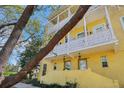 Welcoming three-story yellow townhome featuring dual-level balconies and covered entrances at 958 Sombra St, Tampa, FL 33619