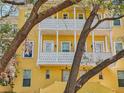 Attractive yellow townhome featuring double balconies and surrounded by mature trees at 958 Sombra St, Tampa, FL 33619
