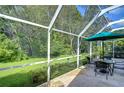 Enclosed patio with outdoor seating, perfect for enjoying the peaceful backyard view in comfort at 10222 Woodford Bridge St, Tampa, FL 33626