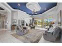 Spacious living room with plush seating, tile flooring, eye-catching ceiling, and access to the outdoor area at 12 Medalist Ter, Rotonda West, FL 33947
