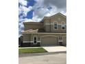 Charming exterior featuring a beige facade, tile roof, and a two-car garage at 1214 Godavari Way, Wesley Chapel, FL 33543