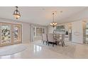 Elegant dining room featuring a glass table, upholstered chairs, decorative lighting, and marble floors at 137 11Th E St, Tierra Verde, FL 33715