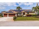 Beautiful single-story home with a well-manicured lawn, mature landscaping, and solar panels on the roof at 137 11Th E St, Tierra Verde, FL 33715
