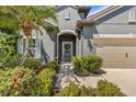 Inviting home entrance showcasing a well-manicured garden and a charming walkway leading to the front door at 1435 Montgomery Bell Rd, Wesley Chapel, FL 33543