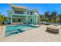 Inviting backyard pool and spa area with a covered outdoor kitchen, perfect for entertaining at 15904 Redington Dr, Redington Beach, FL 33708
