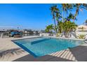 Beautiful pool with clear blue water, surrounded by a spacious patio, and lush tropical landscaping at 15904 Redington Dr, Redington Beach, FL 33708