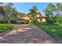 Elegant exterior view of a Mediterranean-style home showcasing a circular brick driveway and lush landscaping at 16205 Sierra De Avila, Tampa, FL 33613