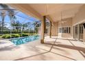 Screened-in lanai with a beautiful pool and view of the well-maintained landscaping at 18823 Wimbledon Cir, Lutz, FL 33558