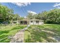 Charming single-story home with a covered porch, lush lawn, and decorative accents creating a welcoming curb appeal at 2708 De Montmollin Rd, Plant City, FL 33565