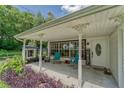 Inviting front porch with seating area, decorative pillars, and a 'Welcome Home' sign, perfect for relaxation and curb appeal at 2708 De Montmollin Rd, Plant City, FL 33565