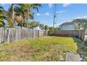 Spacious backyard with a wooden fence providing privacy, and a large grassy area at 3245 11Th N St, St Petersburg, FL 33704