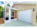 A view of the home's attached garage and covered porch entry, adjacent to the bright front door at 4772 Silver Cir, Zephyrhills, FL 33541