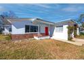 Charming single-story home featuring a red front door, a small porch, and brick accent details at 479 80Th Way, St Pete Beach, FL 33706