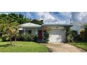 Charming single-story home featuring a red door and a well-maintained lawn, providing great curb appeal at 479 80Th Way, St Pete Beach, FL 33706