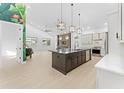Bright, open kitchen with stainless steel appliances, island with dark cabinets, and adjacent living area at 4907 15Th N Ave, St Petersburg, FL 33710