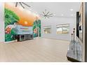 Open living area with a mural accent wall, light wood floors, and ample natural light at 4907 15Th N Ave, St Petersburg, FL 33710